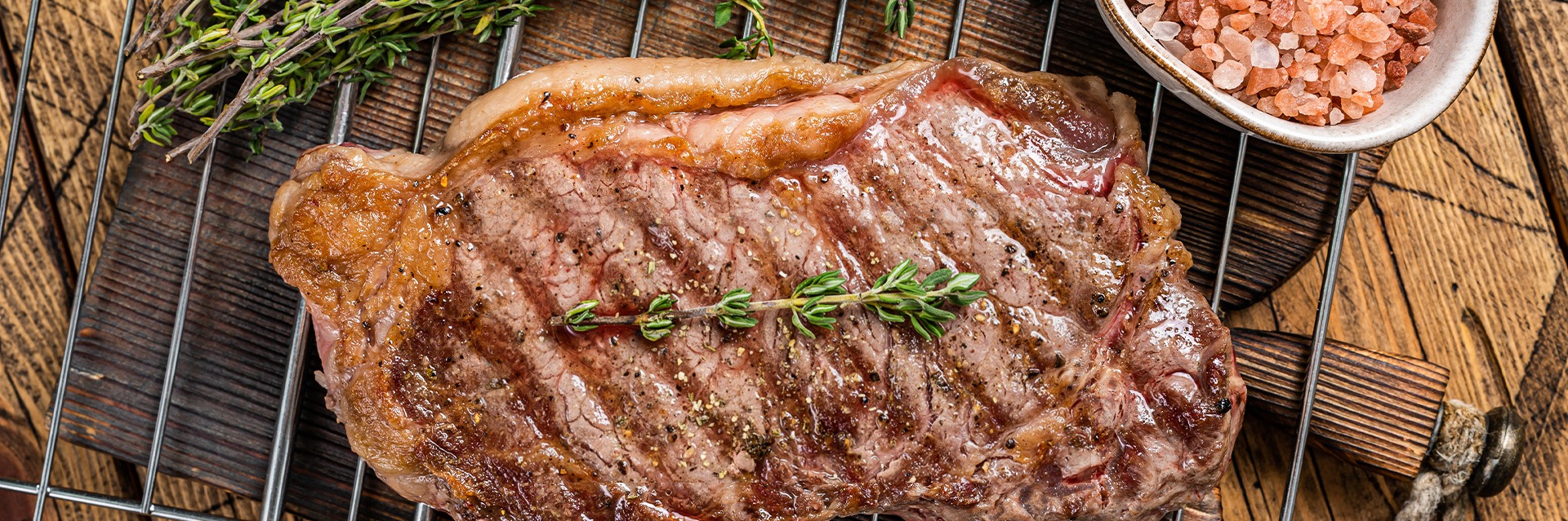 Grilled Ribeye with Garlic Butter – Premium BBQ Steak | Roatan Provision Grilled ribeye steak with garlic butter and herbs served as a premium BBQ dish at Roatan Provision.